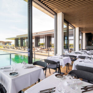 Aufnahme vom Restaurant Scheiblhofer mit gedeckten Tischen. Im Hintergrund ein Pool.