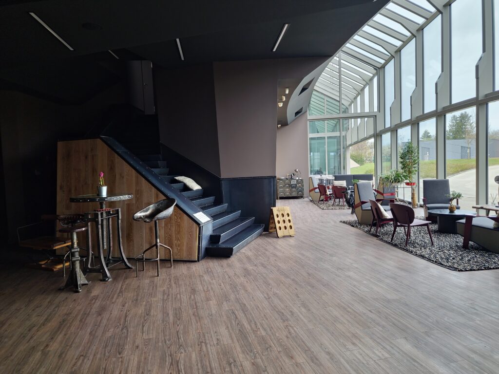 Foto von der Lobby vom Kreinbacher Birtok mit Stühlen uns Sessel vor einer großen und hohen Glasfront.