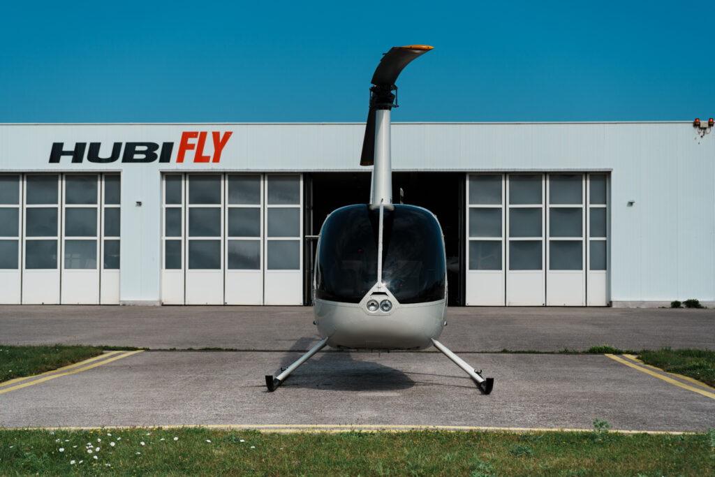 Frontansicht R44 Cadet, im Hintergrund HubiFly Hangar