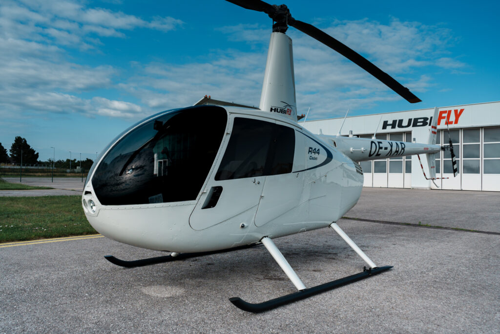 Nahaufnahmen aussen, Robinson R44 Cadet in weiß am Vorfeld