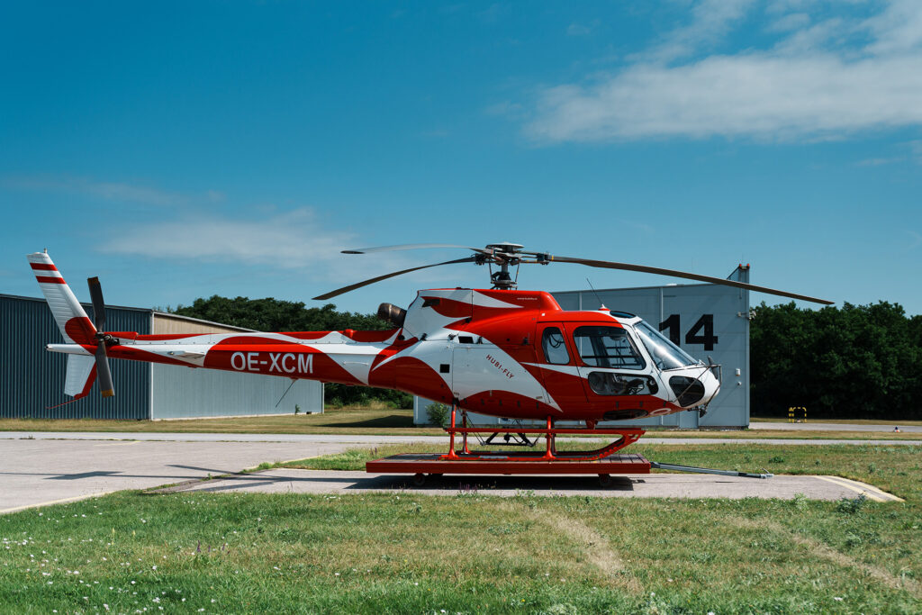 Seitenaufnahme eines AS350 B2 Helikopters in rot weiß rot