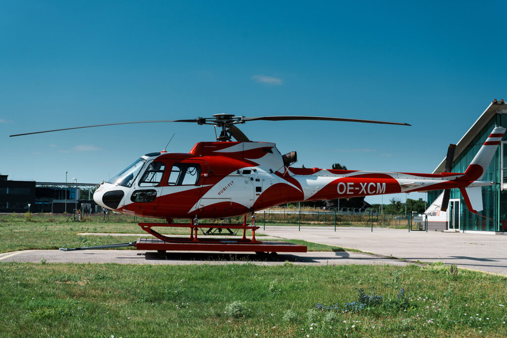 Seitenaufnahme eines AS350 B2 Helikopters in rot weiß rot