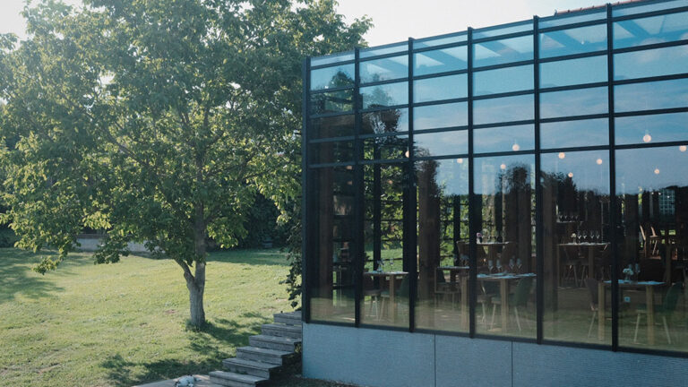 Aussenaufnahme Restaurant und Wintergarten. Ein großer Baum und Garten.