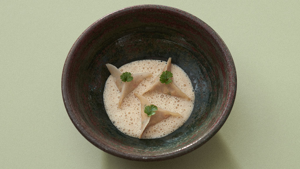 Brauner Teller mit Kohlrabi Suppe, edel angerichtet.